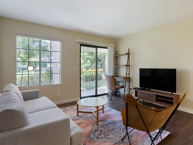 Furnished+ apartment homes come outfitted with a sofa, side chair, side table, coffee table, TV stand and 50" Television (Representative Image exact items and style of furnishings may vary)