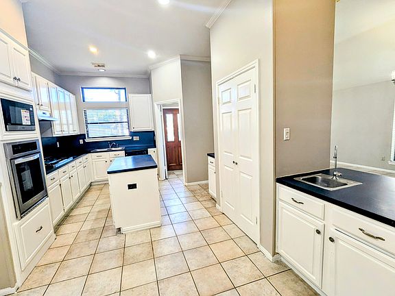 A wet bar seamlessly connects the kitchen and dining room, making it ideal for entertaining and gatherings.