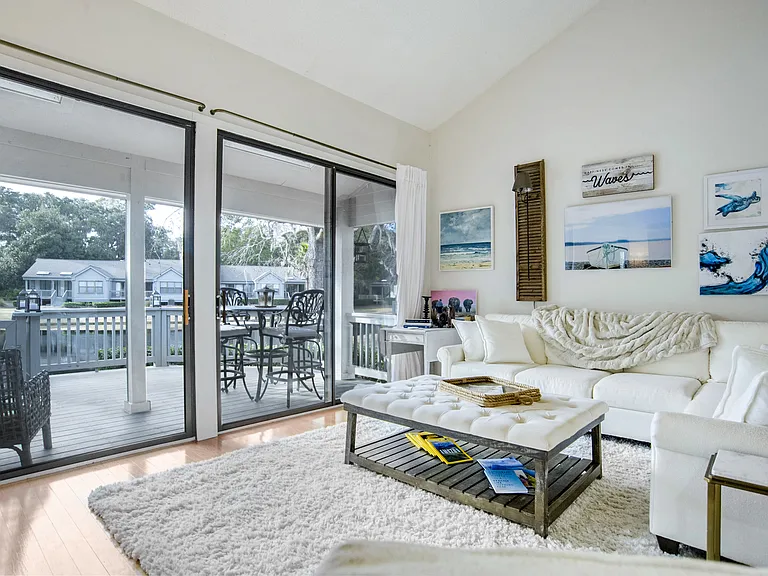 Natural light floods the spacious living room, with vaulted ceilings, plush furnishings, and a cozy coastal design. Enjoy seamless indoor-outdoor living with large sliding doors leading to the deck and water views. And don't leave Fido home alone!