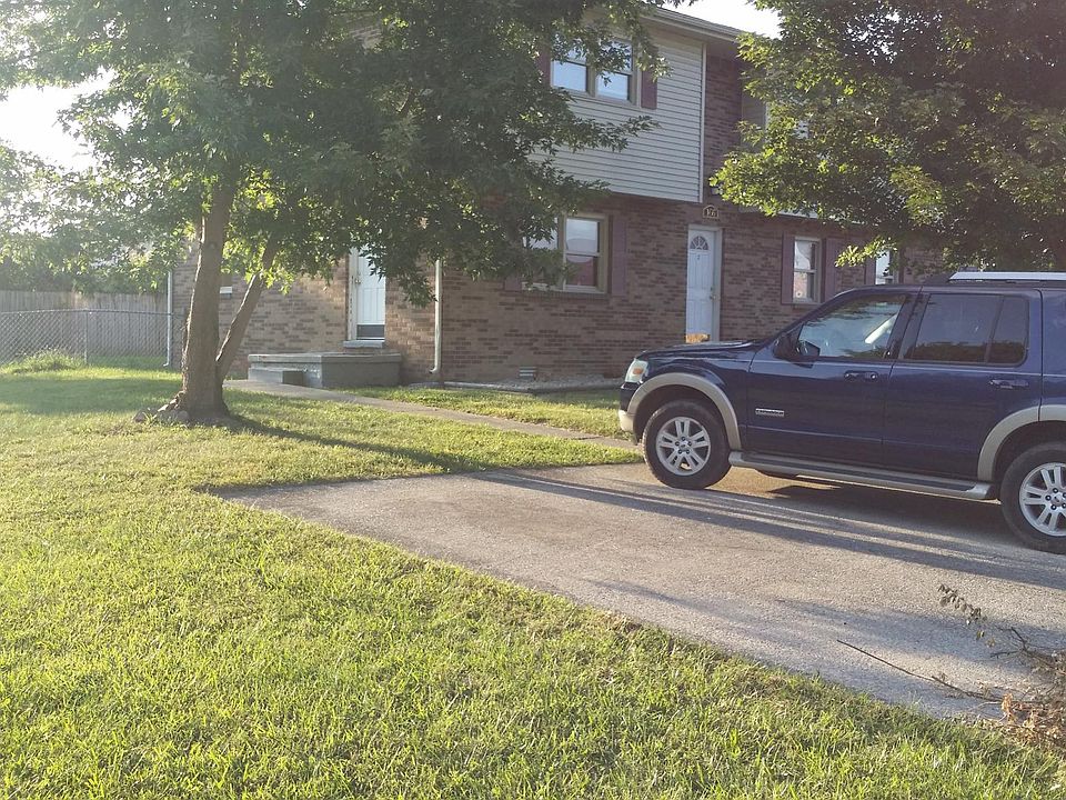 Parking space, yard, entry porch and door.