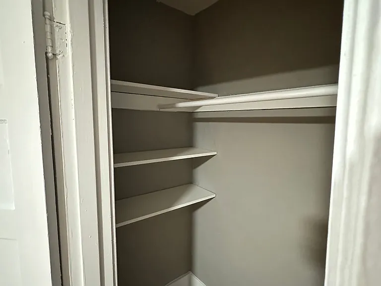 A white refrigerator with its door open and empty shelves.