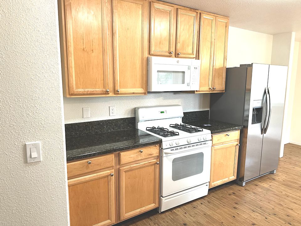 left side kitchen Stove overhead microwave and fridge
