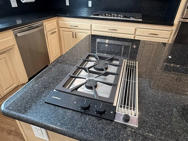 Kitchen island with granite counter and built-in Gaggenau cook-top