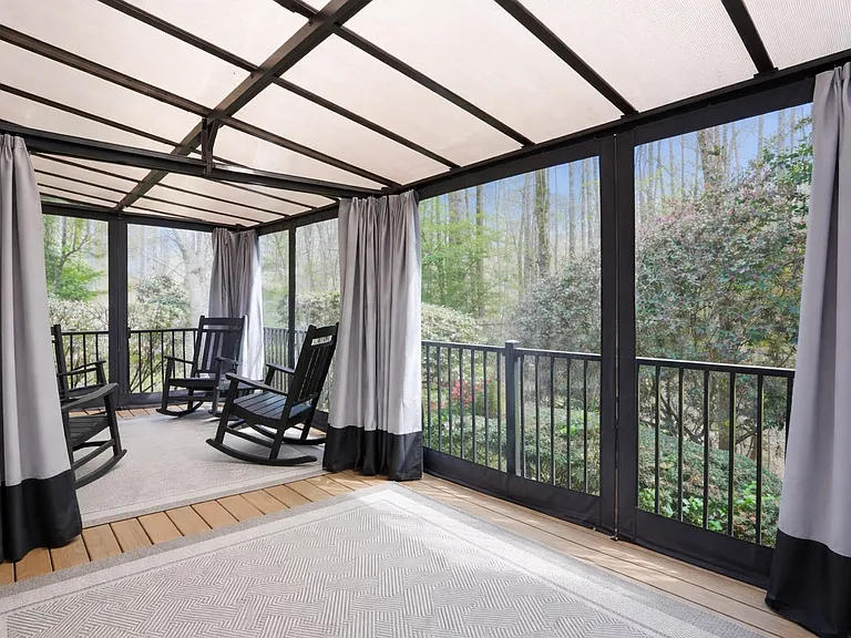 Covered outdoor deck offering a comfortable space to relax and enjoy the surrounding greenery