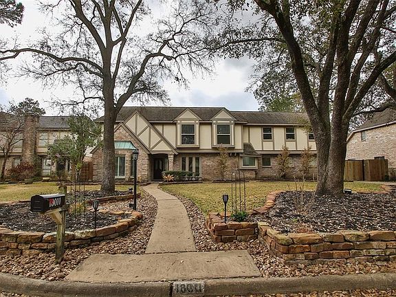 The home sits far off the street and offers large trees and flower gardens.