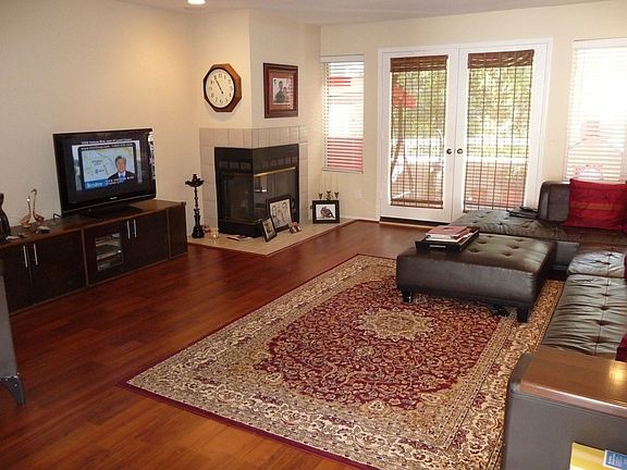 Living room with fireplace, wood laminate floors and built i