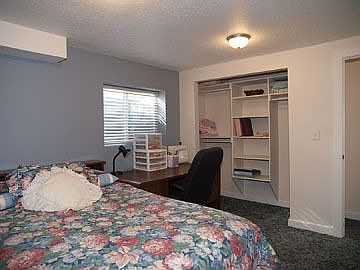 Basement Bedroom w/ built-in wood closet organizer and walk-in storage closet