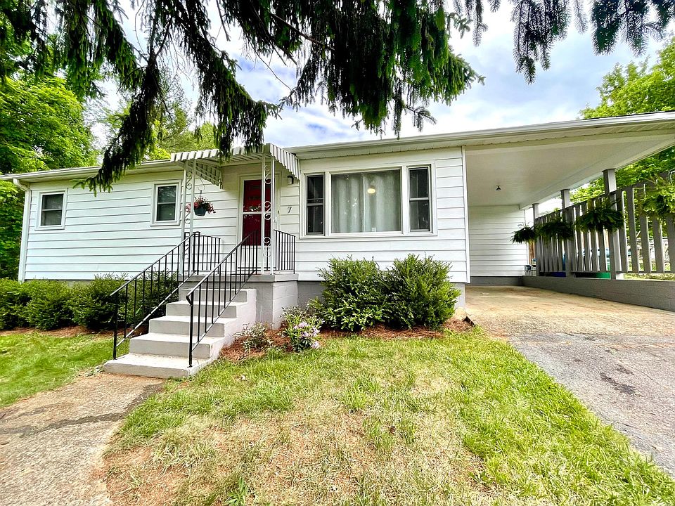 7 Patton Pl has a huge evergreen providing ample shade in the front yard. The covered carport area leads directly into the kitchen for easy unloading.
