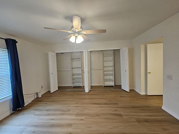 Master Bedroom Suite with spacious closets, fan, and blackout curtains