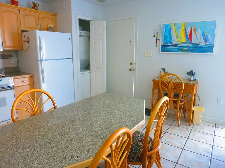 Dining area, a work area with a small desk, and a stackable washer and dryer.