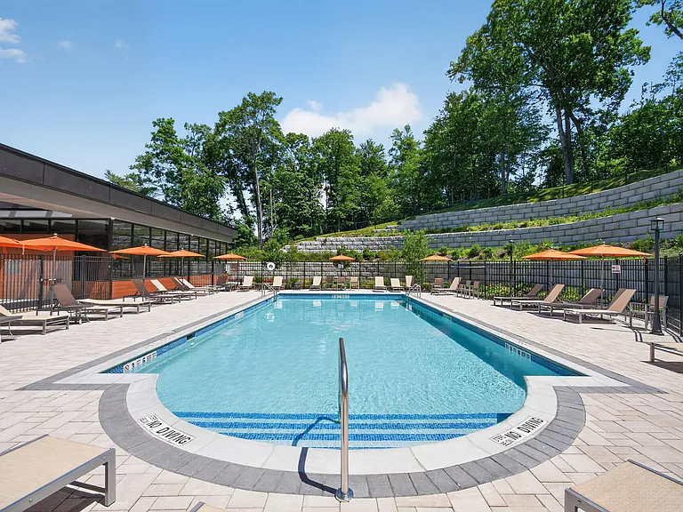 Relax by the stunning pool at Eagle Rock Apartments at Woodbury, surrounded by lush greenery and inviting lounge areas. This oasis is perfect for unwinding or socializing. Schedule a tour today and see what awaits you!