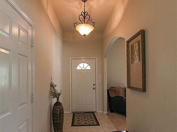 Spacious entry with high ceilings and a chandelier.