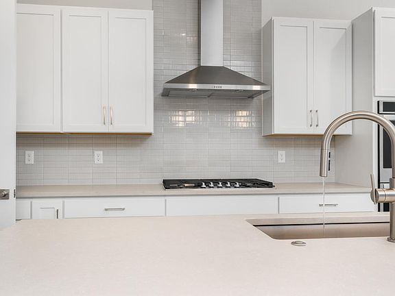 Beautiful quartz countertops and Kohler fixtures highlight the kitchen