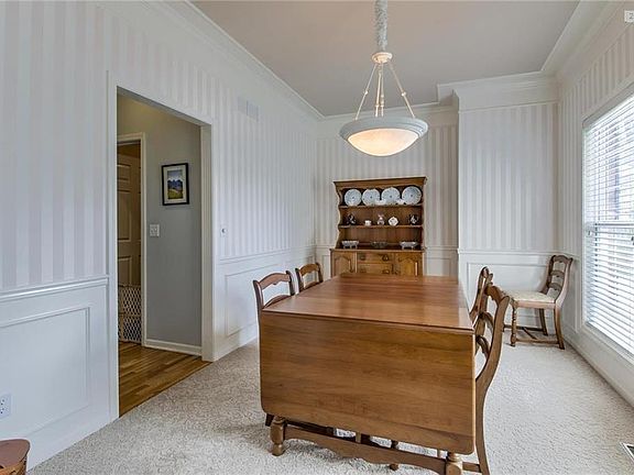 Formal dining room with crown molding and library paneling.