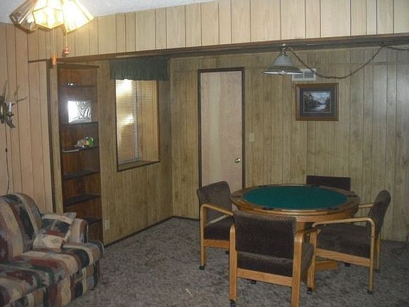 large game room dwn stairs with poker table and wood burning stove