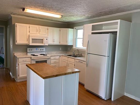Remodeled kitchen, with new dishwasher, microwave, island, sink, faucet, and cabinet handles.