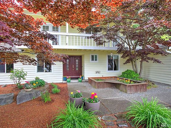 The front door features a raised bed with seating area, and you can see a peek-a-boo view of the front deck that runs the length of the front of the home. You can access this lovely space from one of the bedroom's double French doors as well as through the master suite.