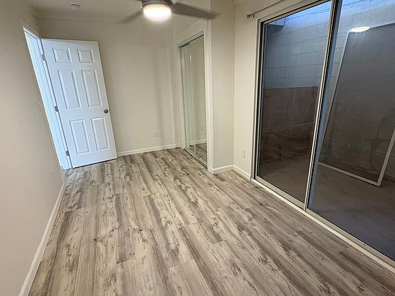 Bedroom with mirror closet doors and sliding door.