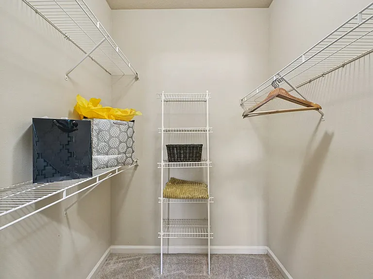 Large walk-in closet with convenient built-in shelving at Village at Broadstone Station apartments in Apex, North Carolina