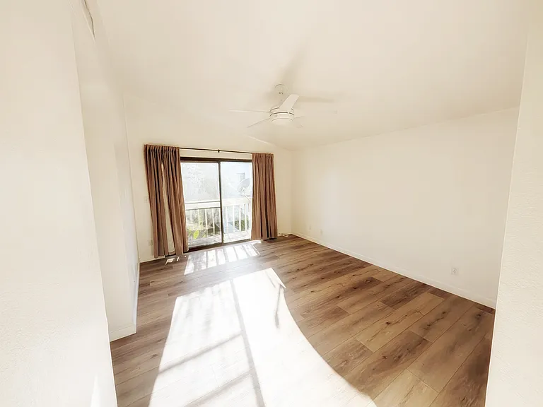 Primary bedroom with balcony overlooking beautiful greenbelt.