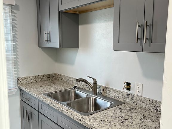 Upgraded kitchen featuring a brand new sink and plumbing fixtures, elegant granite countertop, and stylish vinyl plank flooring.