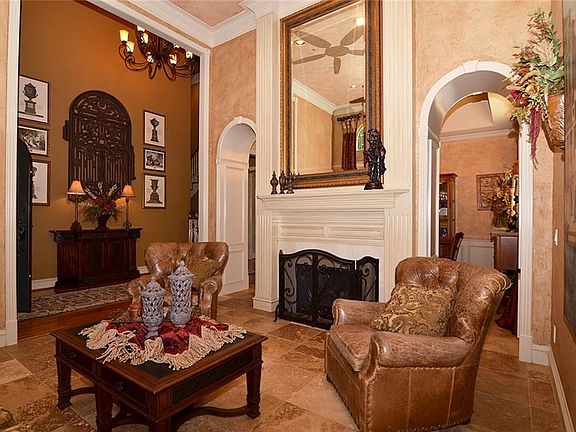 Formal living with Travertine floors, see through fireplace with view of creek.