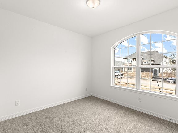 The secondary bedroom features plush carpet, fresh paint, closet, and a large window that lets in pl