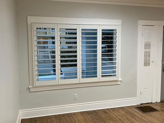 Close-up view of custom plantation shutters and picture windows in the living room.