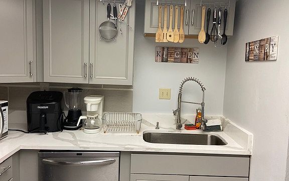 Spacious Kitchen, which includes marble counter top with updated cabinetry, microwave, fridge , air fryer, blender , pots, pans, glasses, plates etc...
