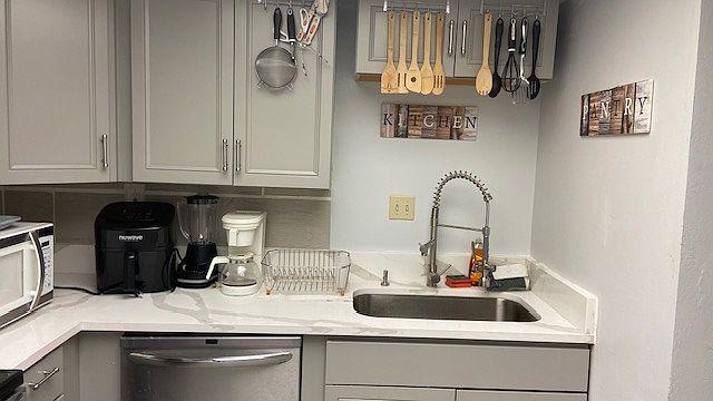 Spacious Kitchen, which includes marble counter top with updated cabinetry, microwave, fridge , air fryer, blender , pots, pans, glasses, plates etc...