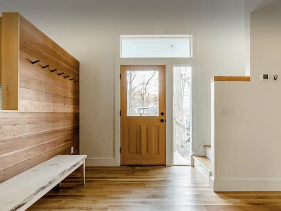 Front entryway, hand hewn recycled wood wall with coat hooks.