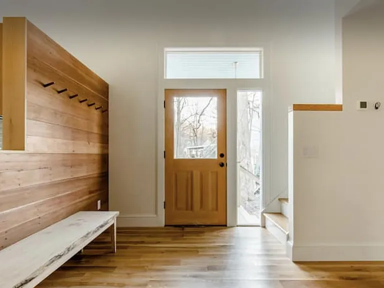 Front entryway, hand hewn recycled wood wall with coat hooks.