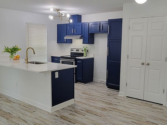 Stacked washer & dryer located behind double doors in photo.