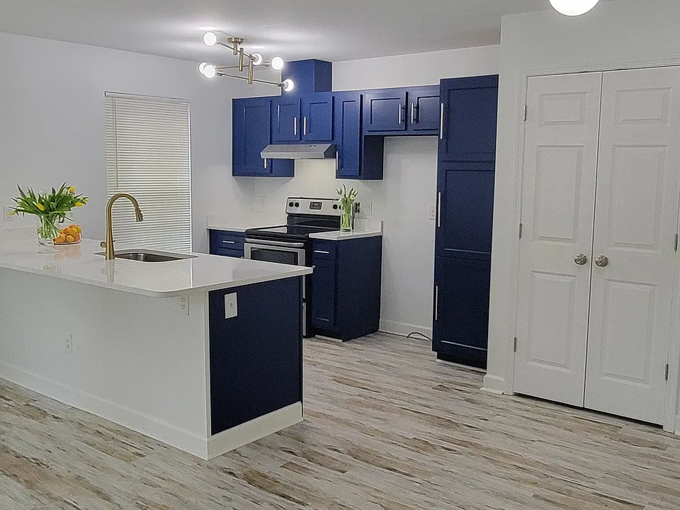 Stacked washer & dryer located behind double doors in photo.