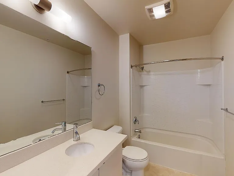 Apartment bathroom with wood-style flooring.
