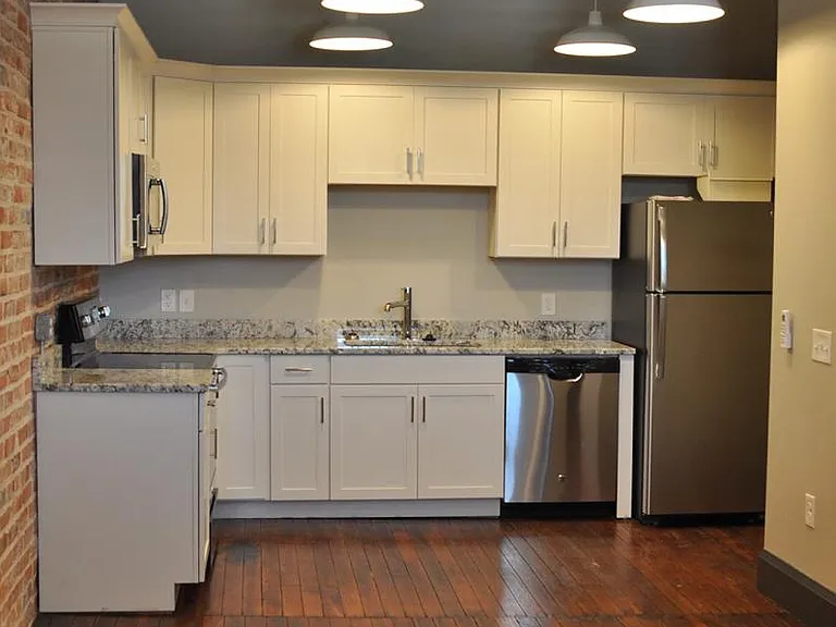 Kitchen view featuring stainless steel refrigerator, dishwasher, and oven/range. Plenty of cabinet space.