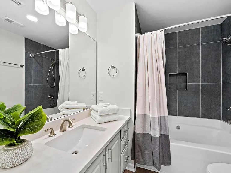 Primary bath, large tub/shower combo with tile surround, plenty of light, and linen closet.