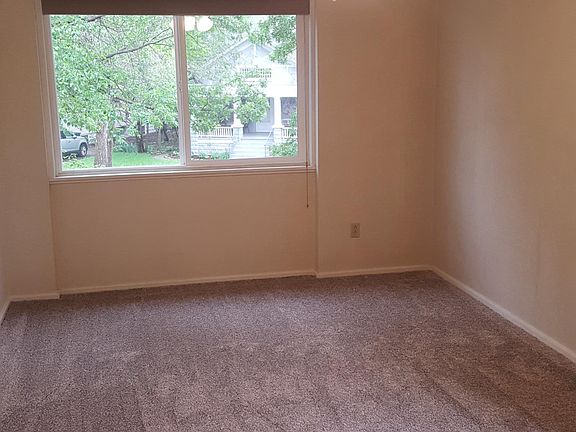 Large bedroom with windows overlooking trees and the park.