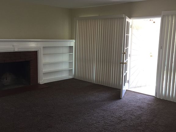 Living room with fireplace and lots of windows.