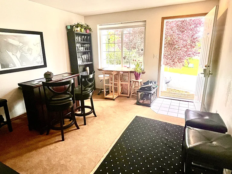 Step inside to a sunlit, versatile front room featuring a beautiful green view of the tree outside. Easily transforms into your dream office, playroom, or dining space.