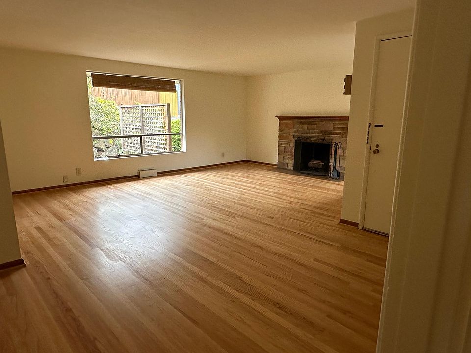 Living room with fireplace and original oak hardwood floors.