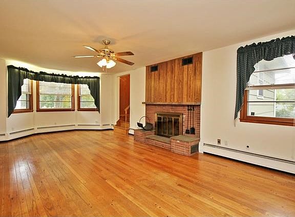Large living room with brick fireplace & dining area.
