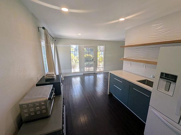 Kitchenette with quart waterfall counters, full size refrigerator, microwave and toaster over.