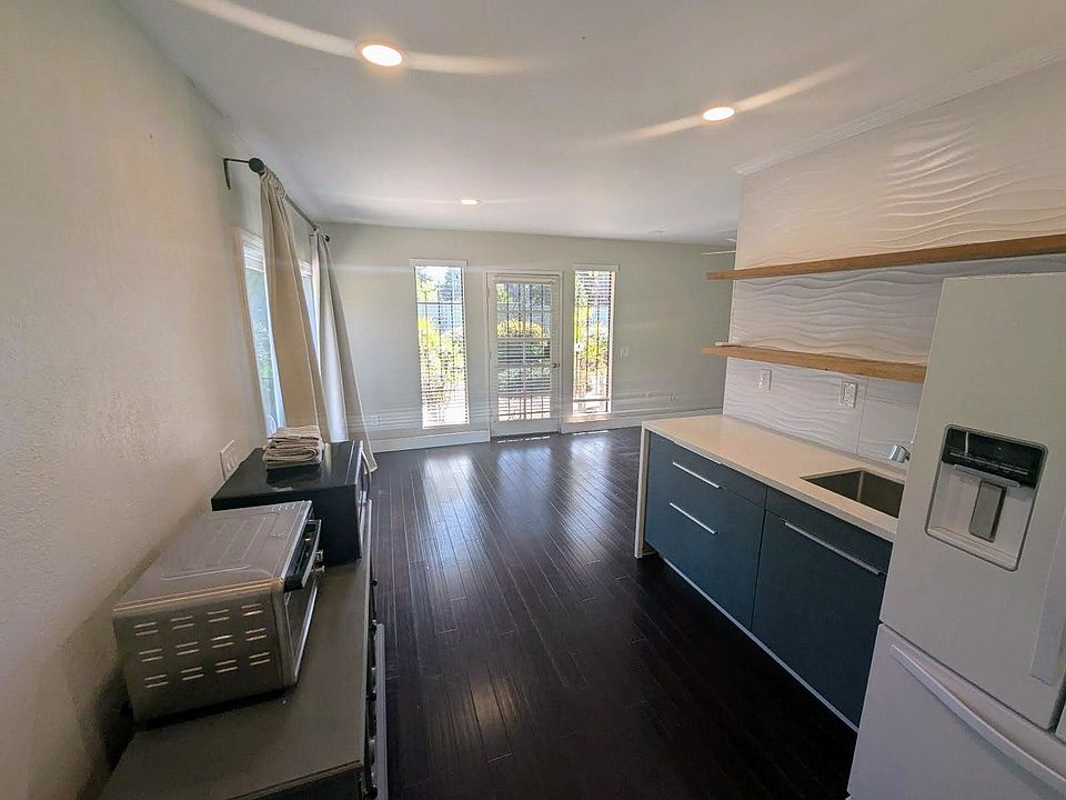 Kitchenette with quart waterfall counters, full size refrigerator, microwave and toaster over.