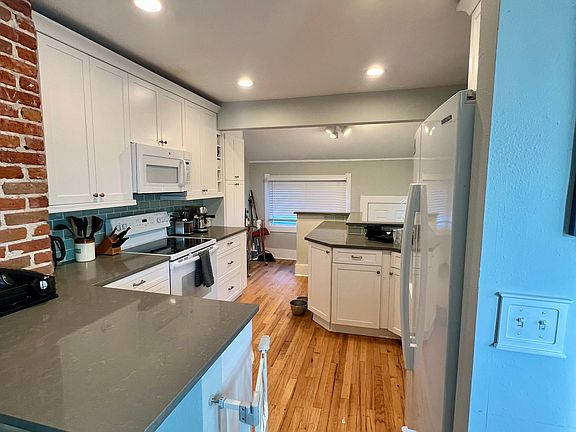 The kitchen comes fully equipped with a microwave, electric stove, and refrigerator-freezer.
