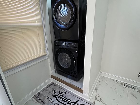 Convenient laundry nook with a stacked washer/dryer set, tucked neatly into a dedicated alcove off the main living areas.