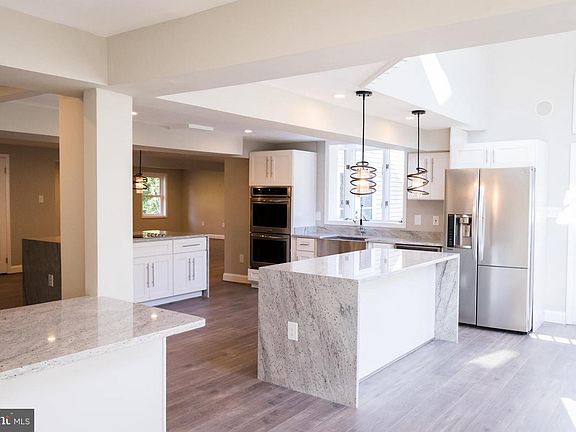 Huge double island gourmet chef's kitchen leading to two story family room.