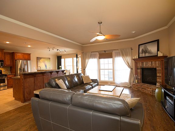 Open Family Room with gorgeous hardwoods, crown moulding, new fan and wall of windows.