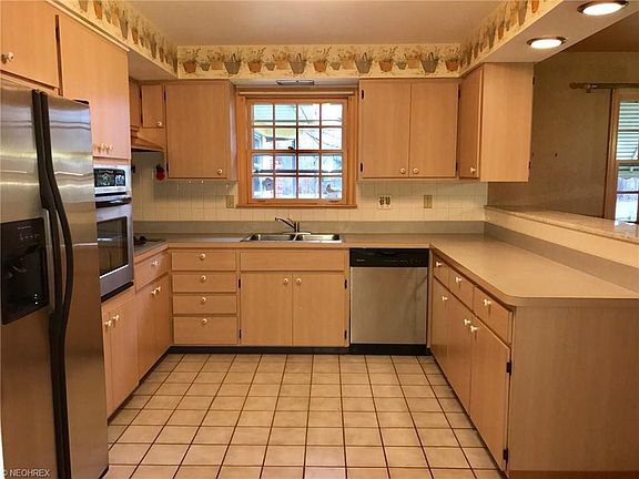 LARGE KITCHEN WITH ALL NEWER STAINLESS STEEL APPLIANCES, CERAMIC FLOOR. PICTURE PAINTED WHITE CUPBOARDS, NO WALL PAPER, PAINTED TAUPE.