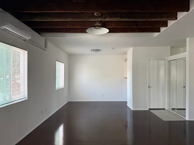 Open plan with exposed rafters and wood floors.